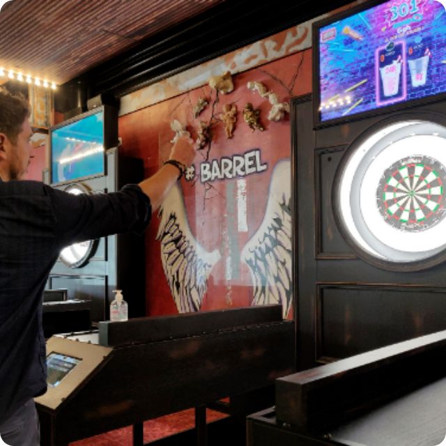 Un joueur lance une flechette sur une cible dans le premier restaurant Barrel à Lesquin